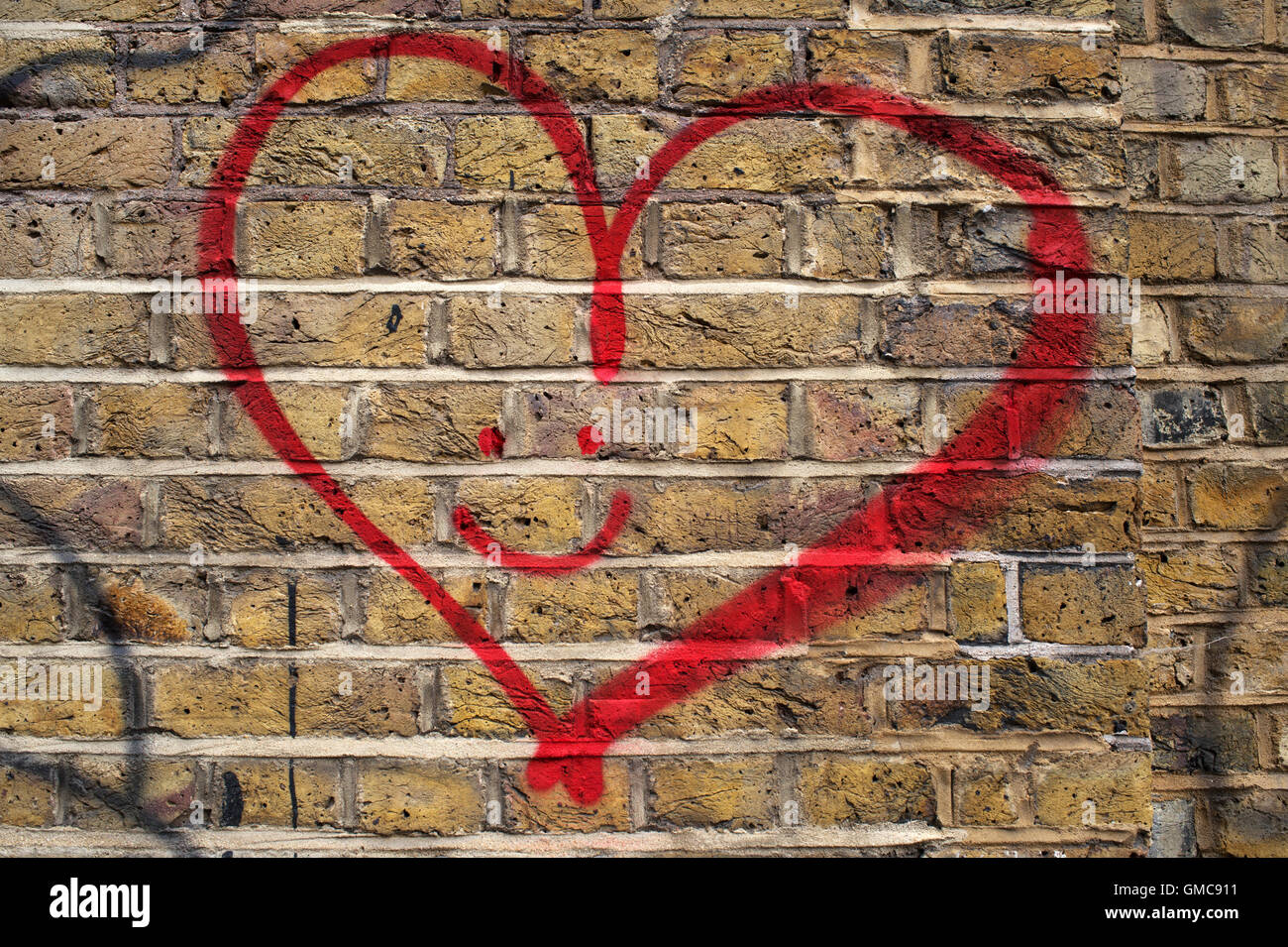 Hackney. Amore cuore graffiti con volto sorridente. Foto Stock