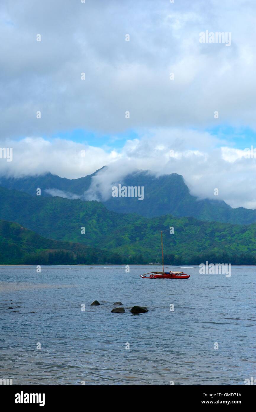 Un catamarano rosso spento il litorale di Kauaii Foto Stock