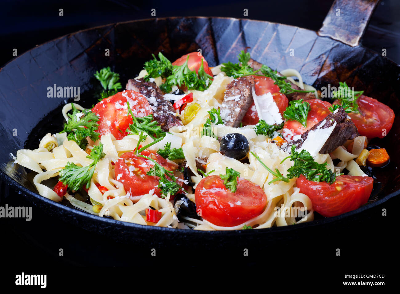 Pasta fresca con i pomodori e le olive in una padella Foto Stock