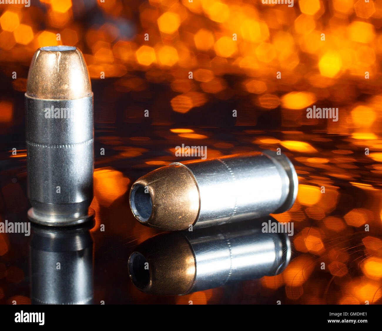 Pistola di munizioni con un punto di cava bullet e uno sfondo arancione Foto Stock