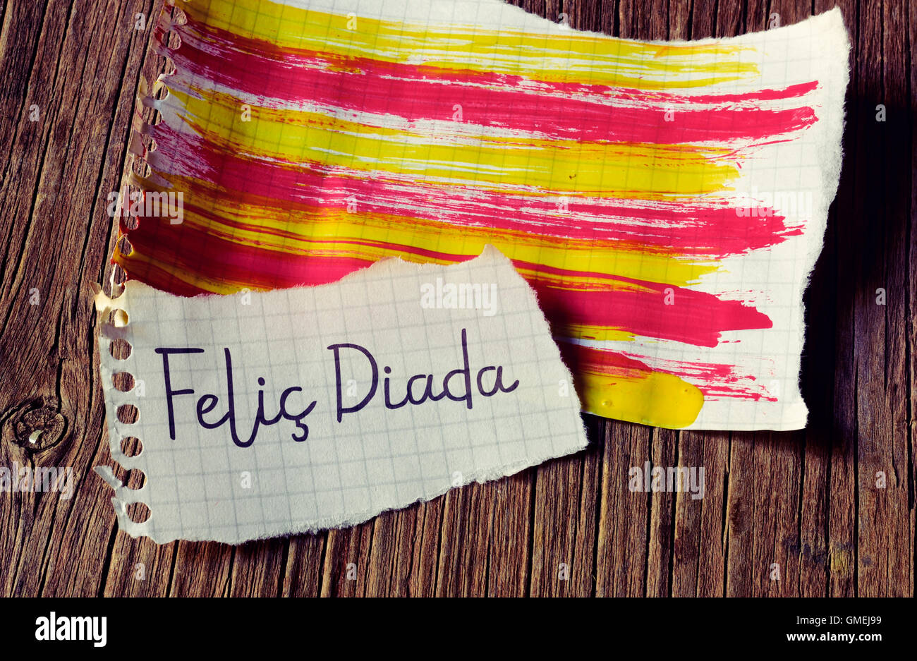 Il testo Felic Diada, Felice Giornata Nazionale della Catalogna in catalano scritto in un pezzo di carta e la bandiera catalana dipinta in un Foto Stock