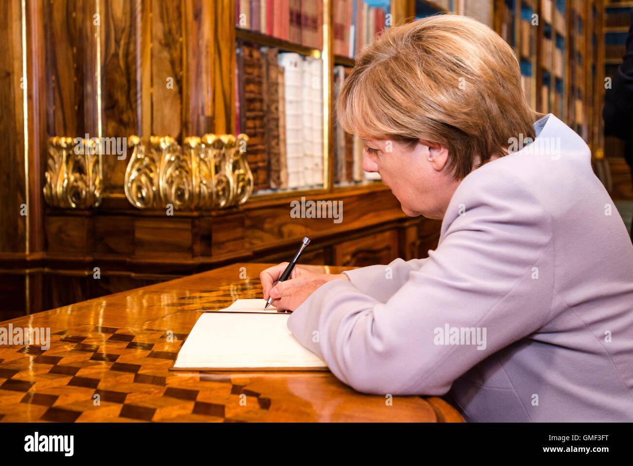 Praga, Repubblica Ceca. 25 Ago, 2016. Il cancelliere tedesco Angela Merkel Firma il libro della rimembranza durante la sua visita della libreria di Strahov entro la sua visita di un giorno a Repubblica Ceca a Praga Repubblica Ceca, 25 agosto 2016. Credito: David Tanecek/CTK foto/Alamy Live News Foto Stock