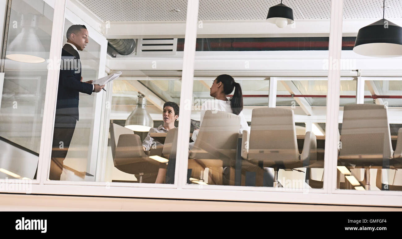 Imprenditore dando una presentazione in un ufficio moderno con pareti in vetro Foto Stock