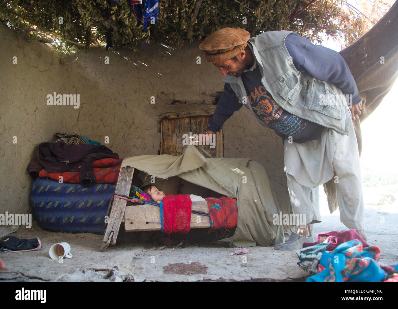 Padre guardando al suo bambino dorme in una culla, Badakshan provincia, Qazi deh, Afghanistan Foto Stock