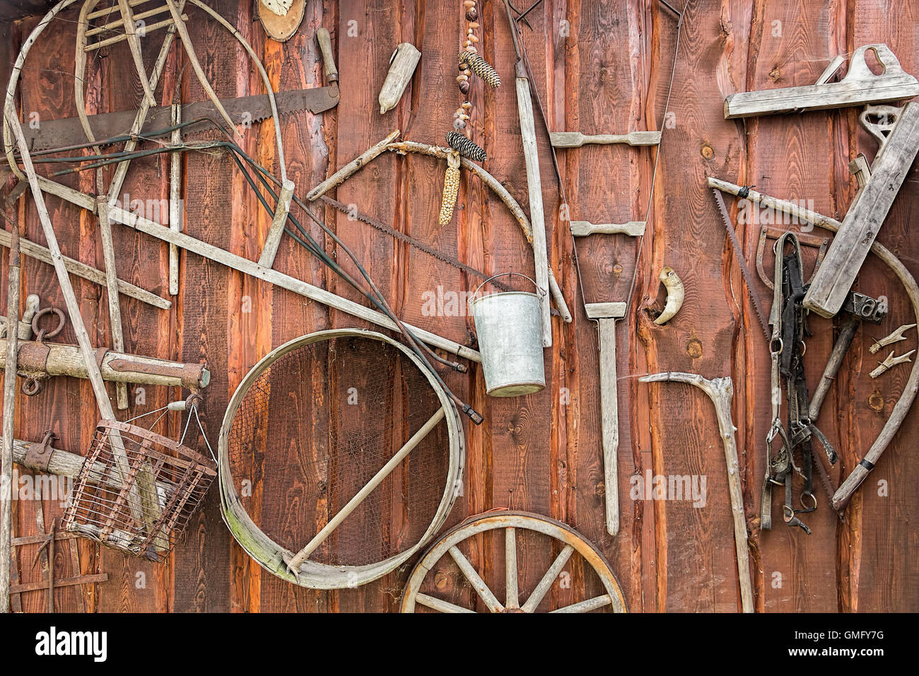 Sfondo rustico, collezione di vecchi vintage attrezzi agricoli sulla parete in legno Foto Stock
