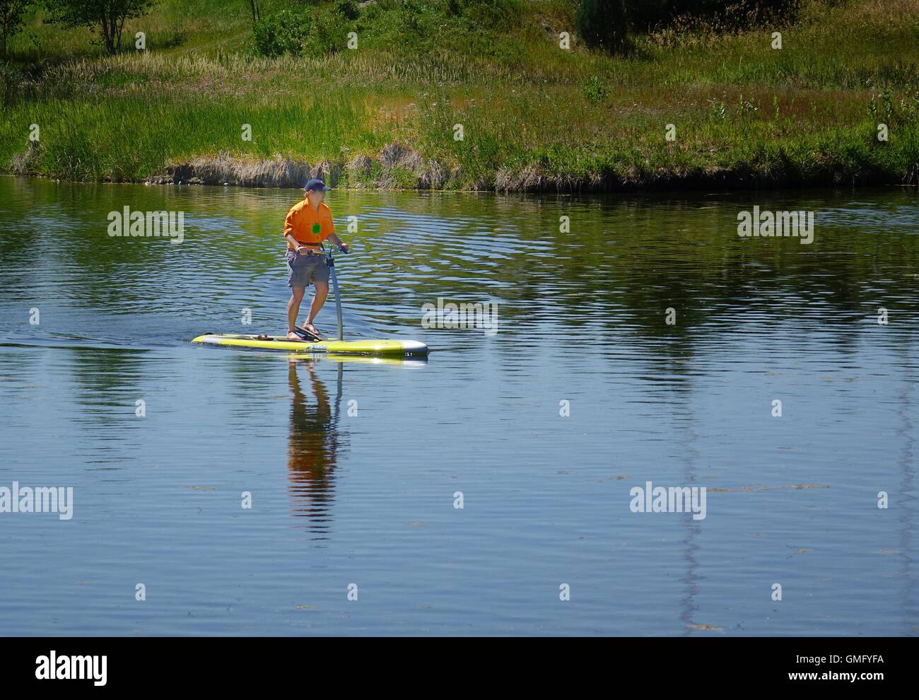 Uomo su Hobie pedale-drive stand-up paddleboard Foto Stock