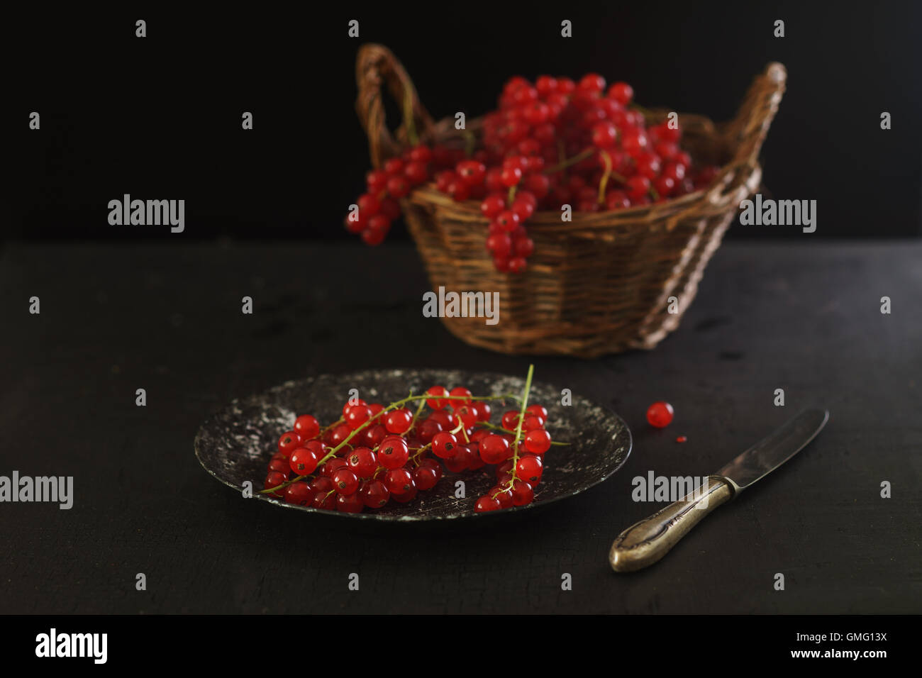 Ribes rosso sulla piastra vintage e tavola nera Foto Stock