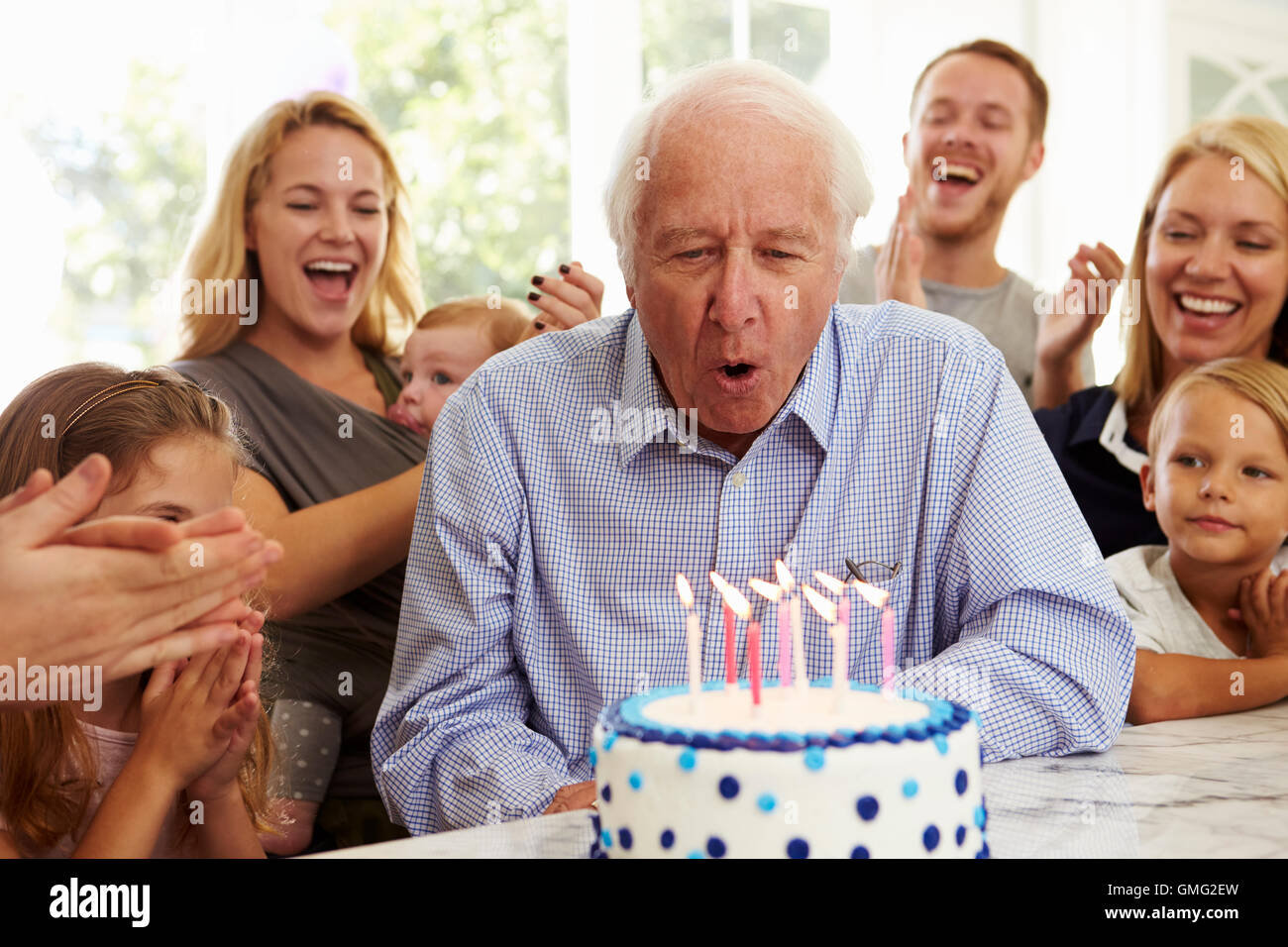 Il nonno si brucia la torta di compleanno candele alla festa di famiglia Foto Stock