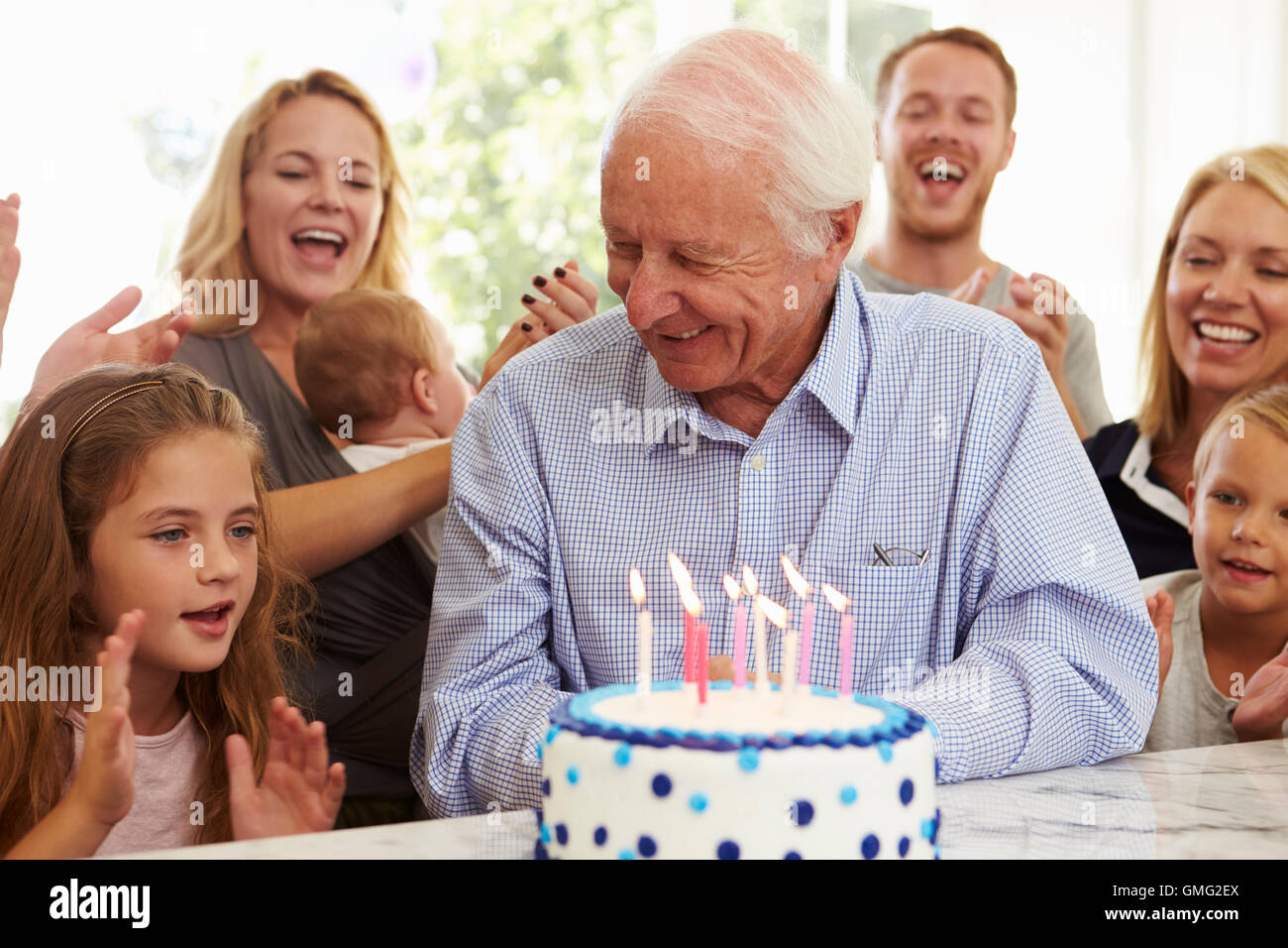 Il nonno si brucia la torta di compleanno candele alla festa di famiglia Foto Stock