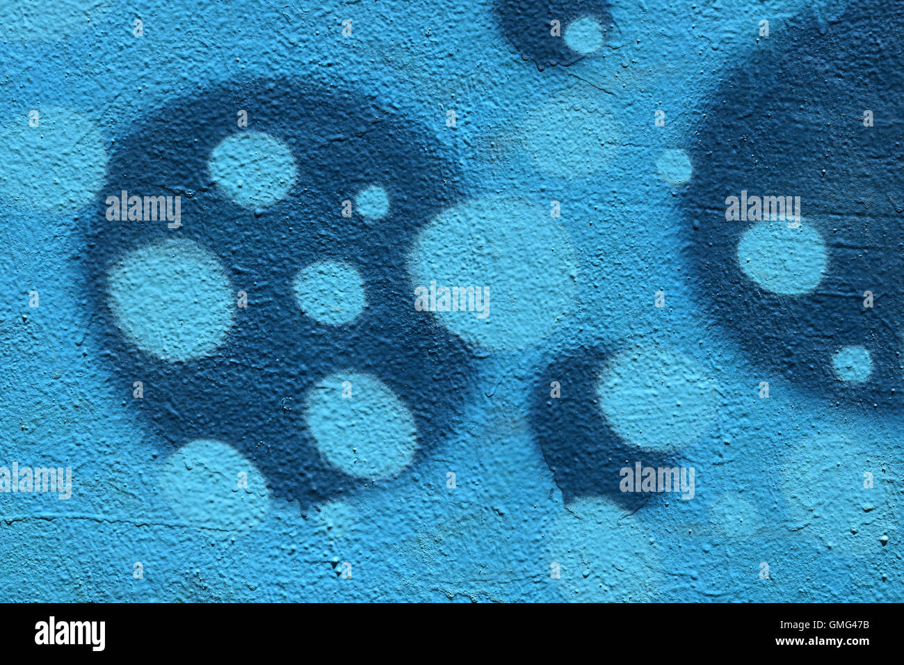 Verniciato a spruzzo punti blu e circoli modello sulla parete testurizzata sfondo. Abstract forme geometriche. Foto Stock