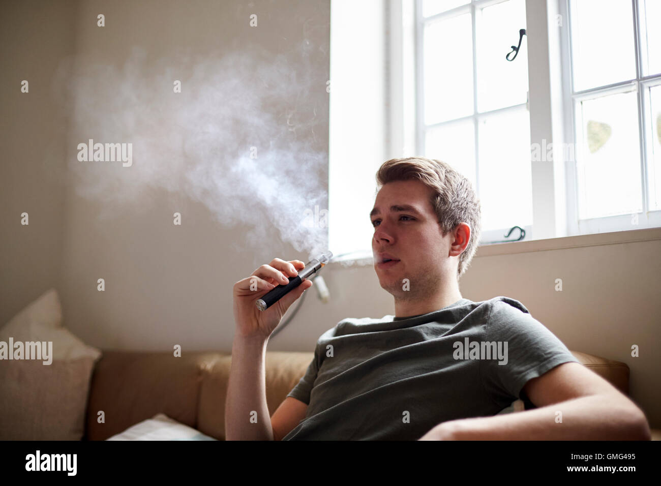 Giovane uomo con vaporizzatore come alternativa per fumatori Foto Stock