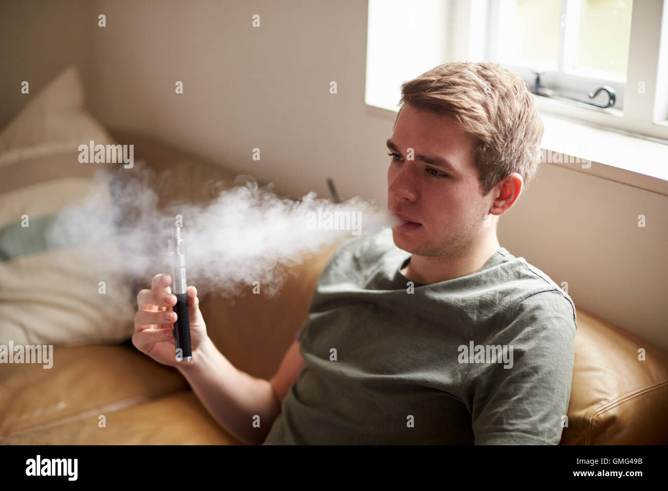 Giovane uomo con vaporizzatore come alternativa per fumatori Foto Stock