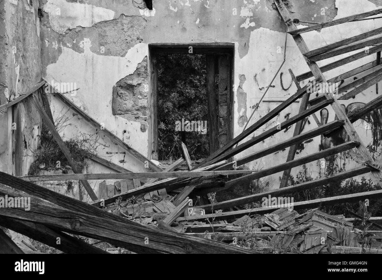 Crollo del tetto scheggiati muri interni e la finestra di una casa abbandonata. In bianco e nero. Foto Stock