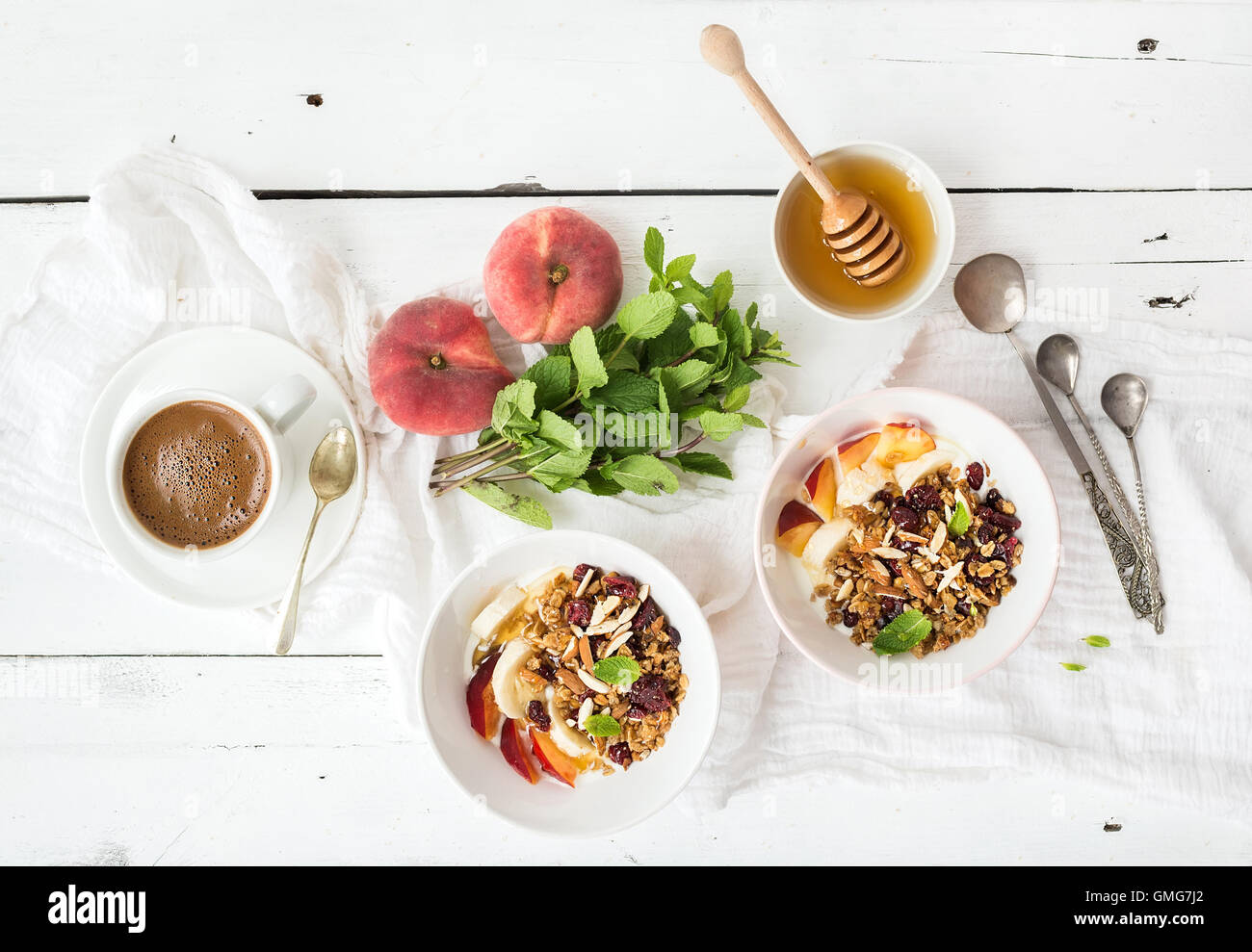 Una sana prima colazione. Ciotola di oat granola con yogurt, frutta fresca, menta e miele Foto Stock