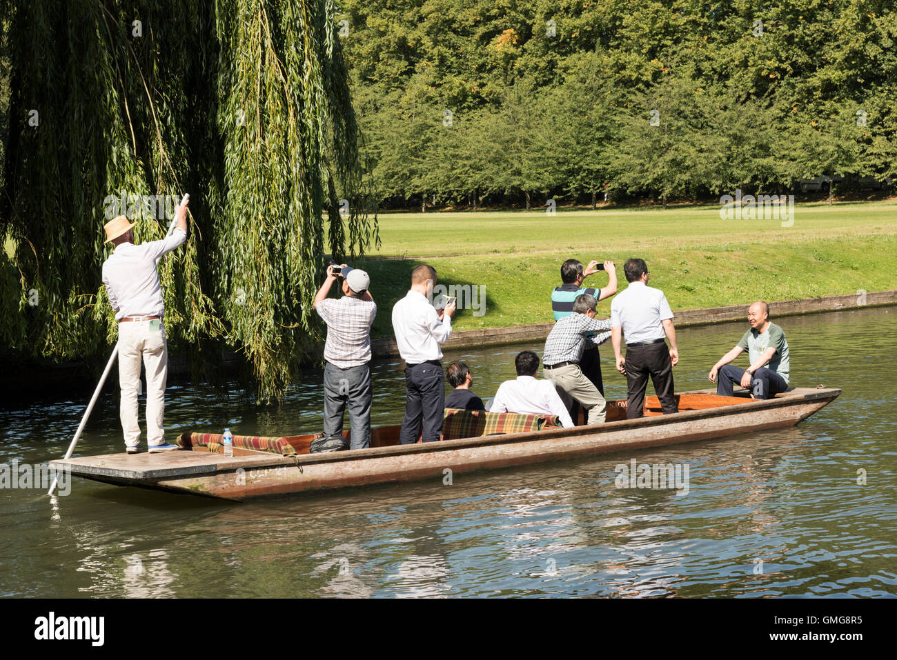 I turisti punting sul fiume Cam sul dorso a Cambridge Regno Unito in estate in piedi nella barca scattare fotografie Foto Stock