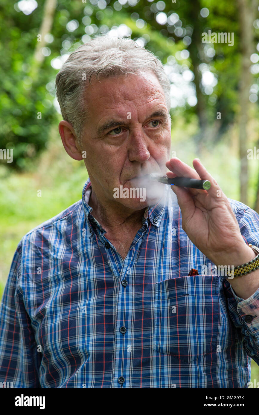 L'uomo vaping con e-sigaretta fuori, Irlanda Foto Stock