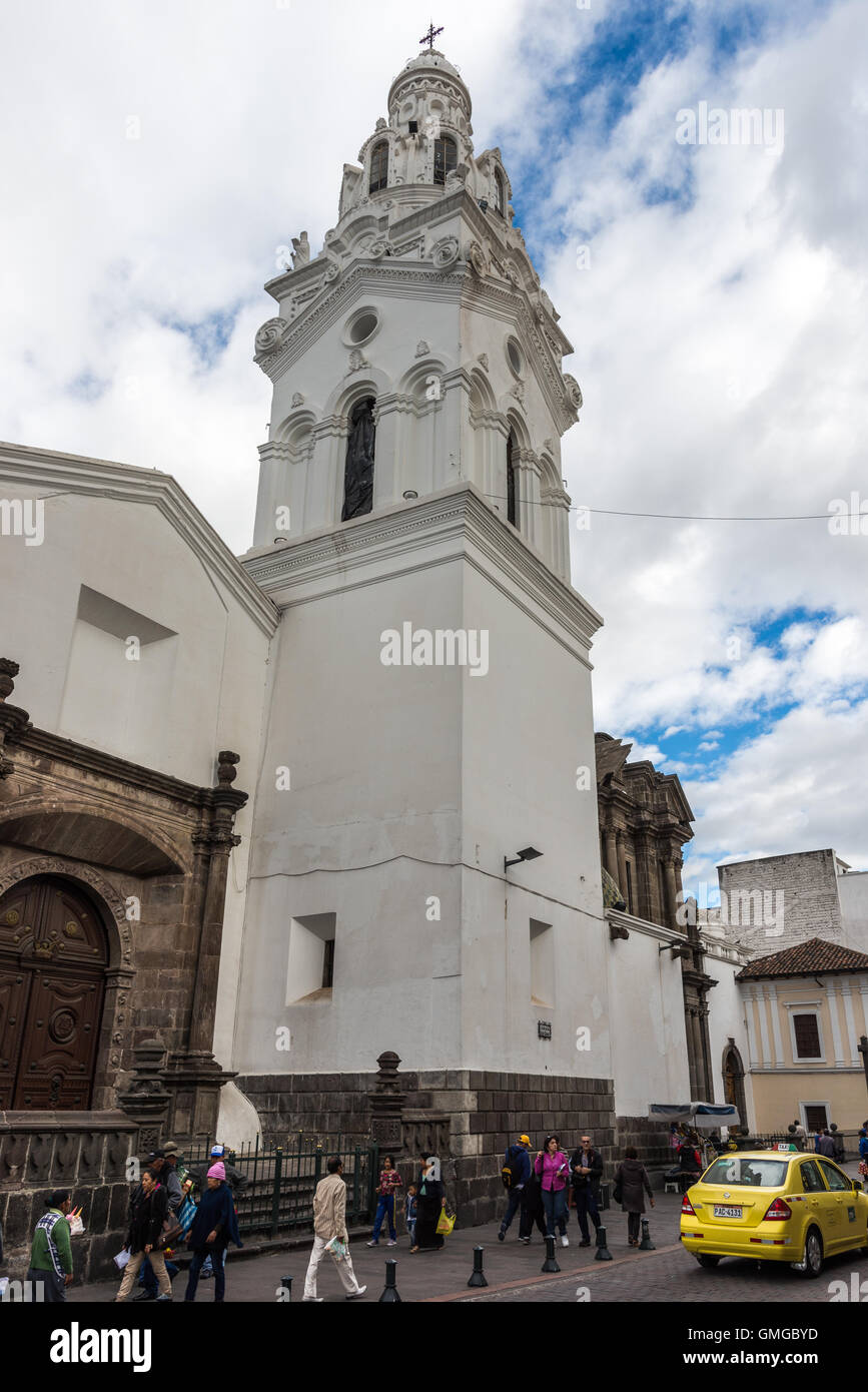 Pedoni passando dalla torre di una chiesa presso la storica città vecchia di Quito, Ecuador. Foto Stock