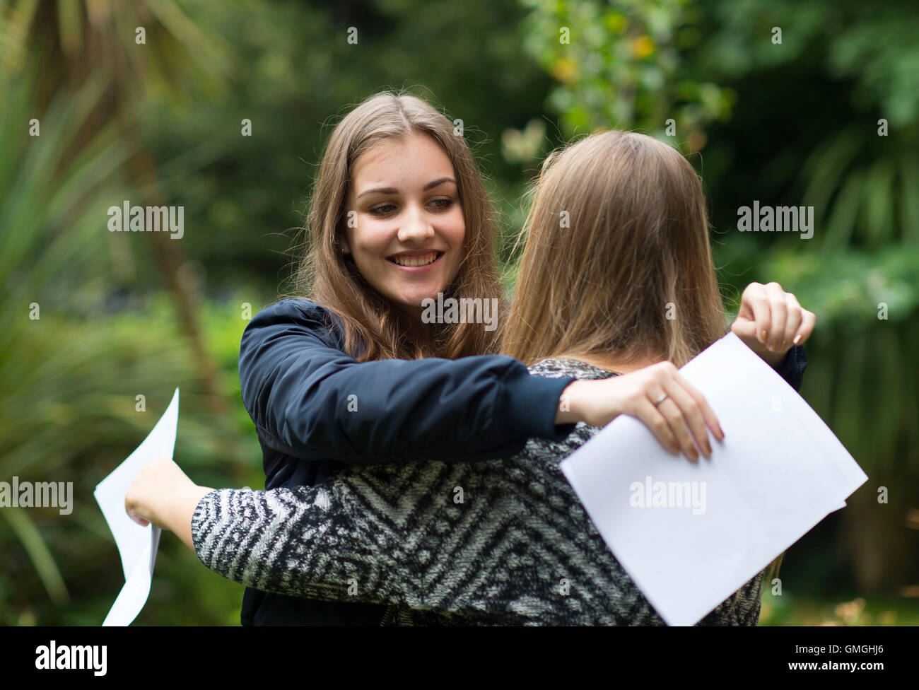 Due ragazze femmina celebrano il loro GCSE risultati esame presso una scuola a Swansea, nel Galles del Sud. Foto Stock