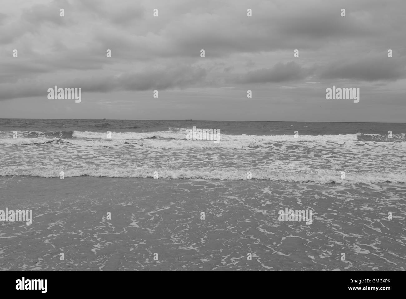 La laminazione delle onde nella spiaggia di Coca in un giorno nuvoloso in Florida. Foto Stock