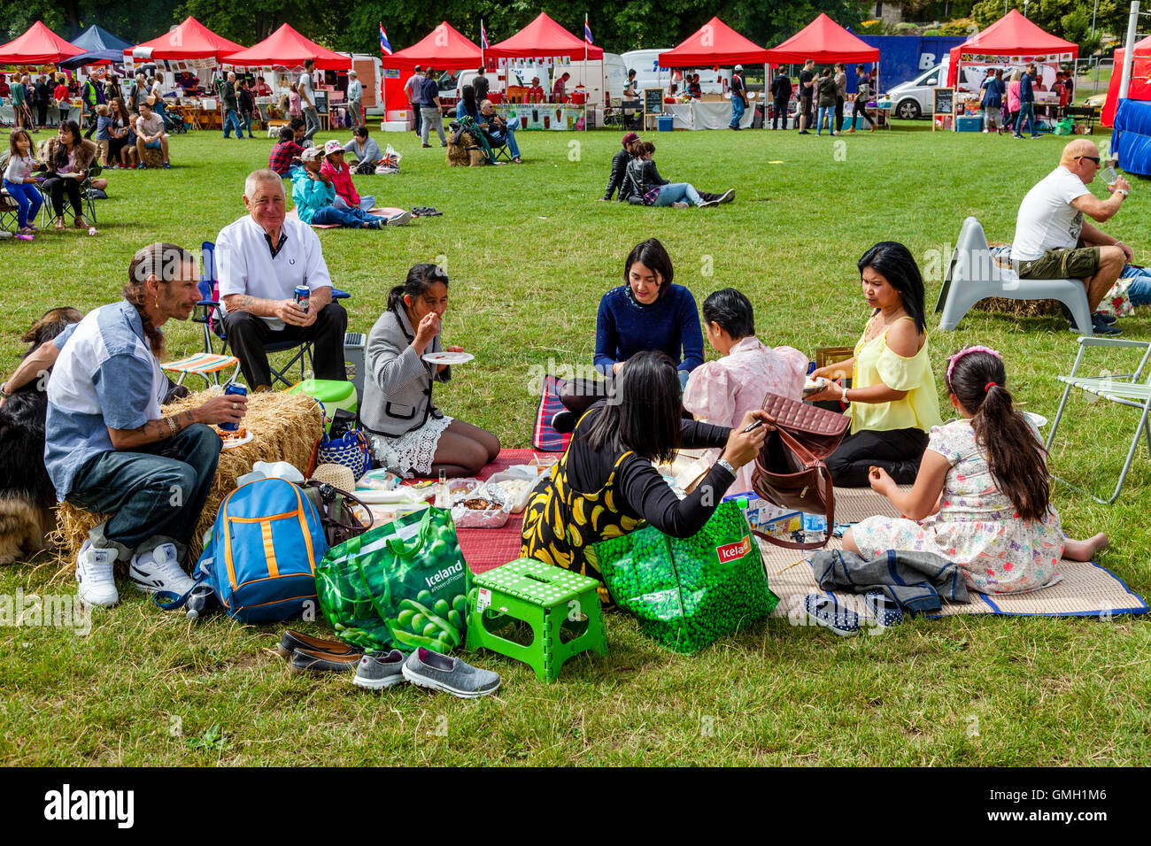 Anglo famiglie tailandese di mangiare un pic-nic durante l annuale Brighton festival Tailandese, Preston Park, Brighton, Sussex, Regno Unito Foto Stock