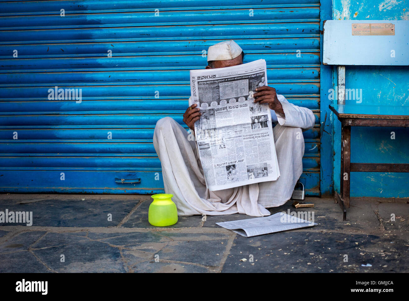 Un abitante di un villaggio leggendo il giornale locale Foto Stock