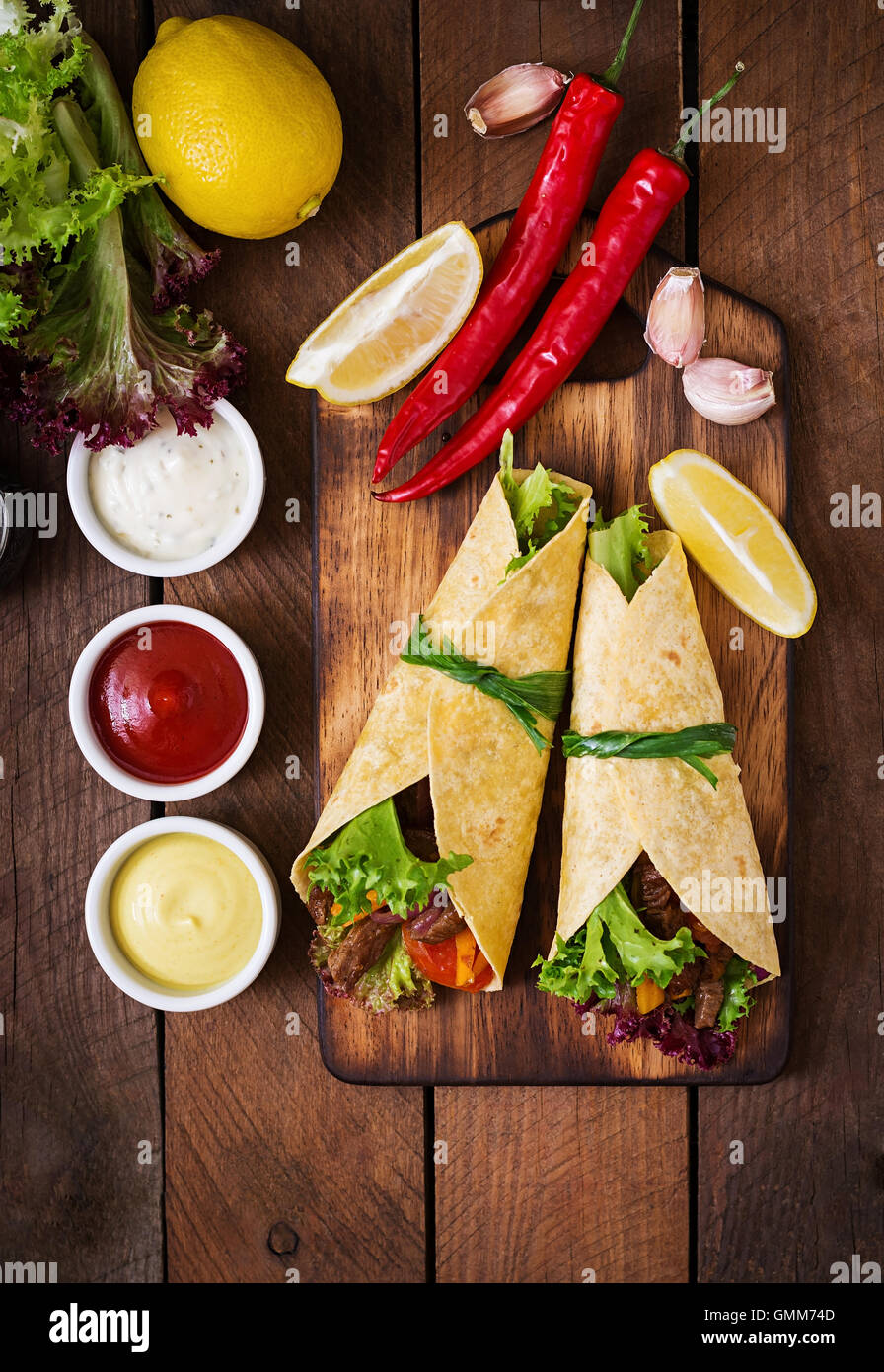 Le fajitas messicane di manzo e verdure alla griglia (paprica, rosso cipolla, pomodoro). Vista superiore Foto Stock