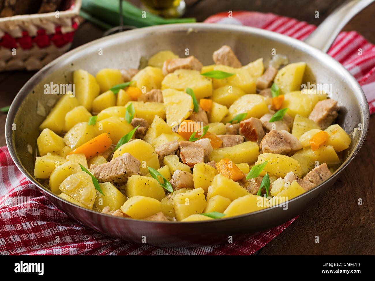 Patate in umido con la carne in una padella su di un tavolo di legno Foto Stock