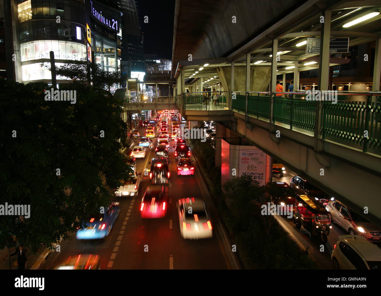 Scena notturna del skywalk di Ashok BTS Station con il collegamento al terminale 21, un quartiere alla moda di complesso per lo shopping nel centro di Bangkok. Foto Stock