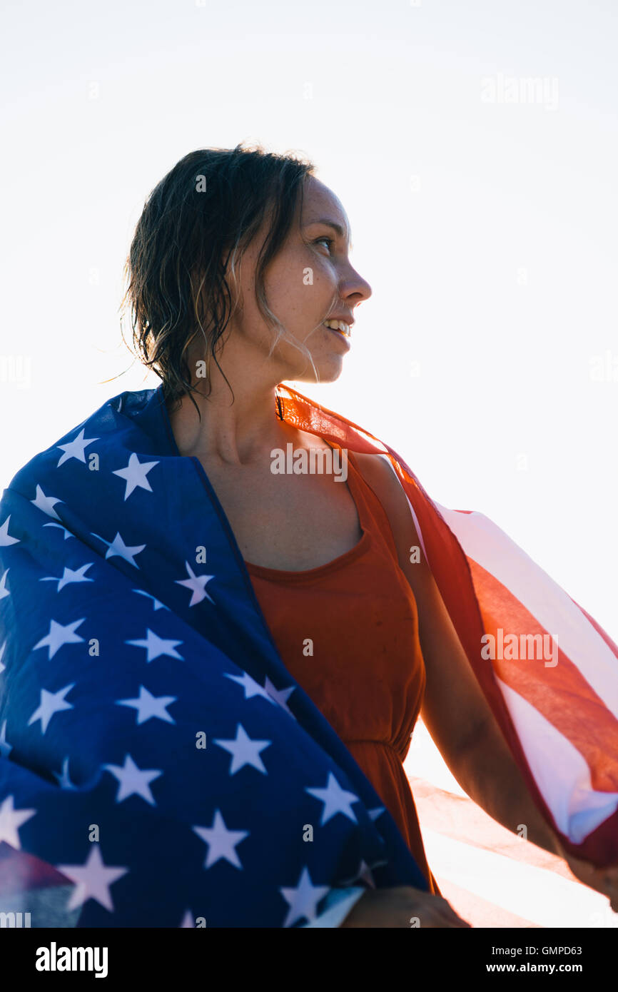 Donna sorridente con i capelli umidi e bandiera americana Foto Stock