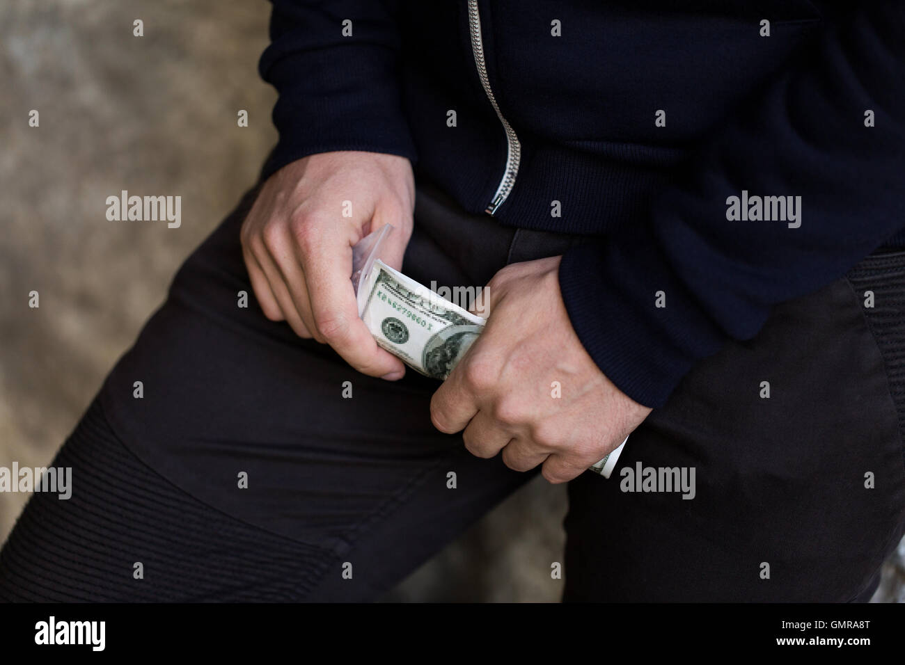 Chiusura del tossicodipendente o spacciatore mani con denaro Foto Stock