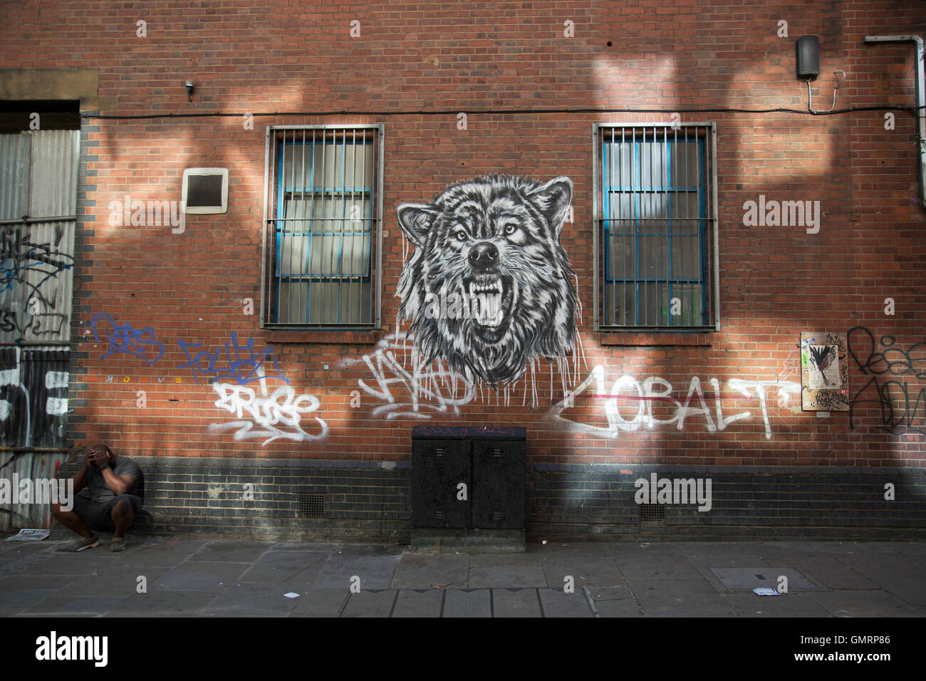 Street Art wolf su Brick Lane in Shoreditch, East London, Regno Unito. Arte di strada nella East End di Londra è un sempre mutevole enigma visiva, come le opere cambiano costantemente, come consigli pulire alcuni muri o nuove opere andare fino al posto di altri. Mentre alcuni considerano questo vandalismo o graffiti, queste opere sono molto popolare tra la popolazione locale e i turisti come un senso di intensità rimane nel lavoro, molti dei quali hanno i messaggi sottili. Foto Stock