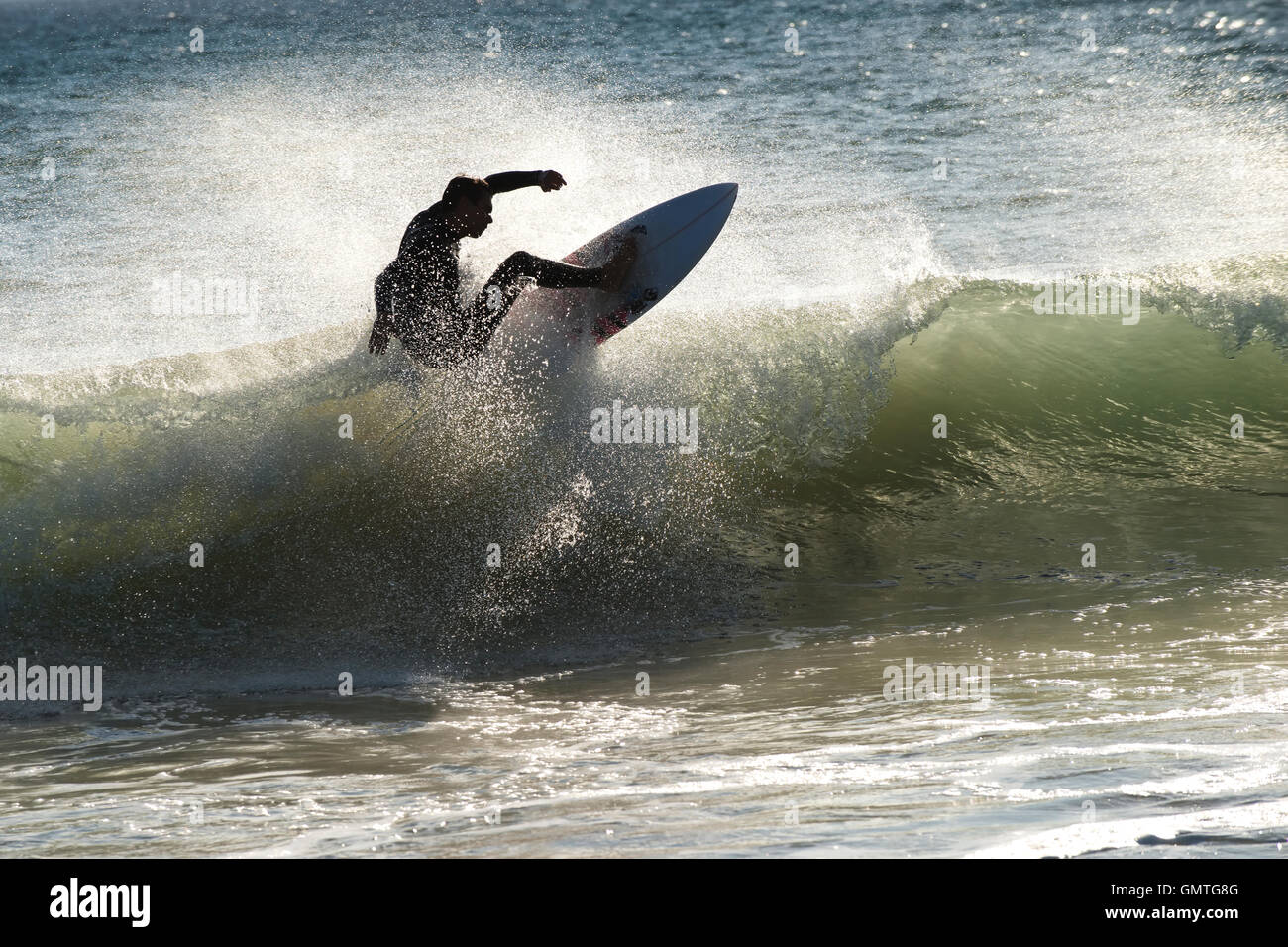 Surfer sport onda drammatico spray di acqua di mare verde soleggiata surfboard velocità potenza oceano adventure uomo Foto Stock