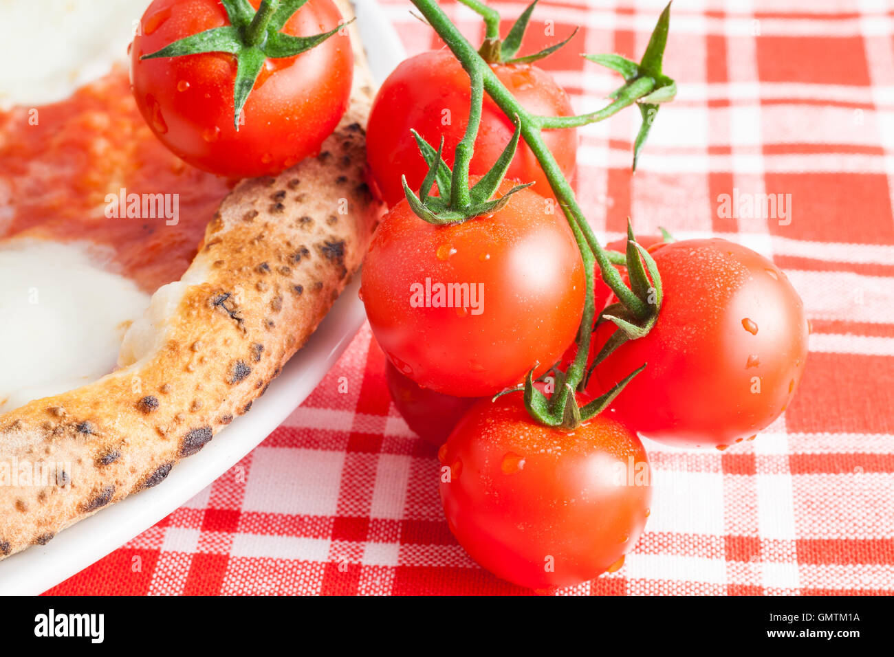 Dettaglio di una vera pizza italiana a Napoli con pomodori ciliegino Foto Stock