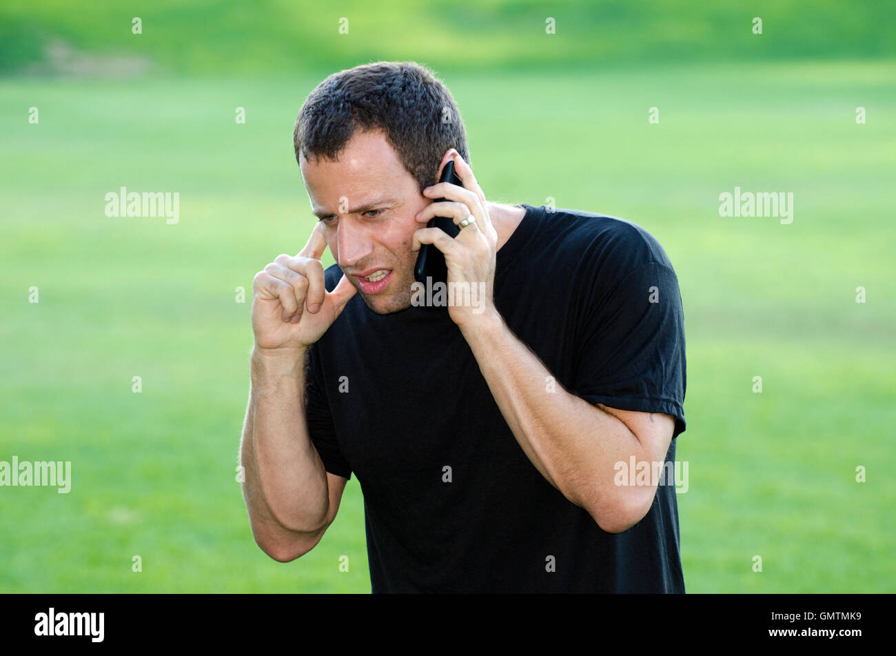 Il servizio di telefonia cellulare di male? L'uomo avente un tempo duro audizione sul suo telefono cellulare, collegamento errato. Foto Stock