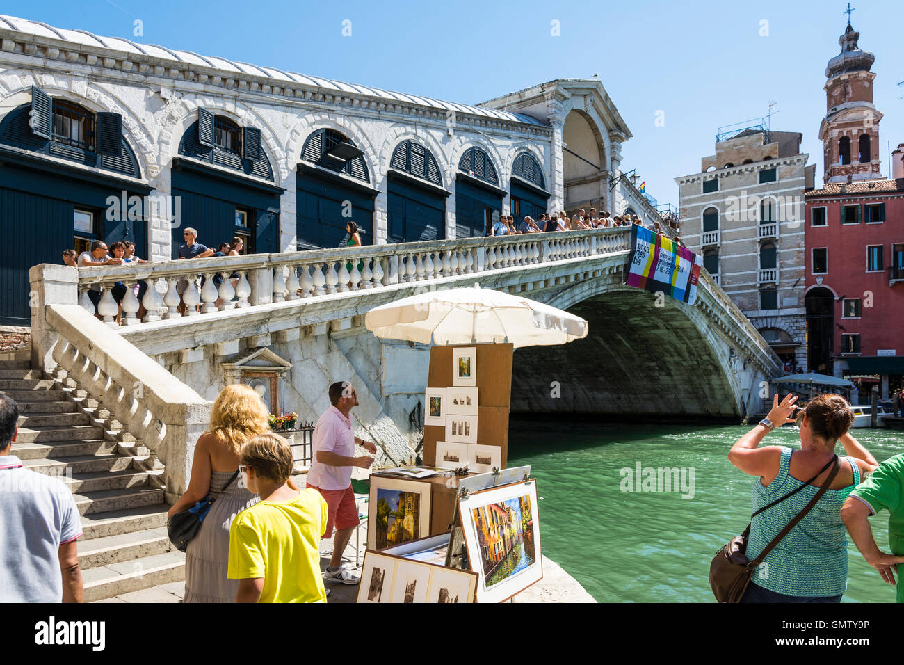 Venezia,Italy-August 17,2014:persone e passeggiata turistica e prendere le foto sul ponte di Rialto di Venezia durante una giornata di sole. Foto Stock