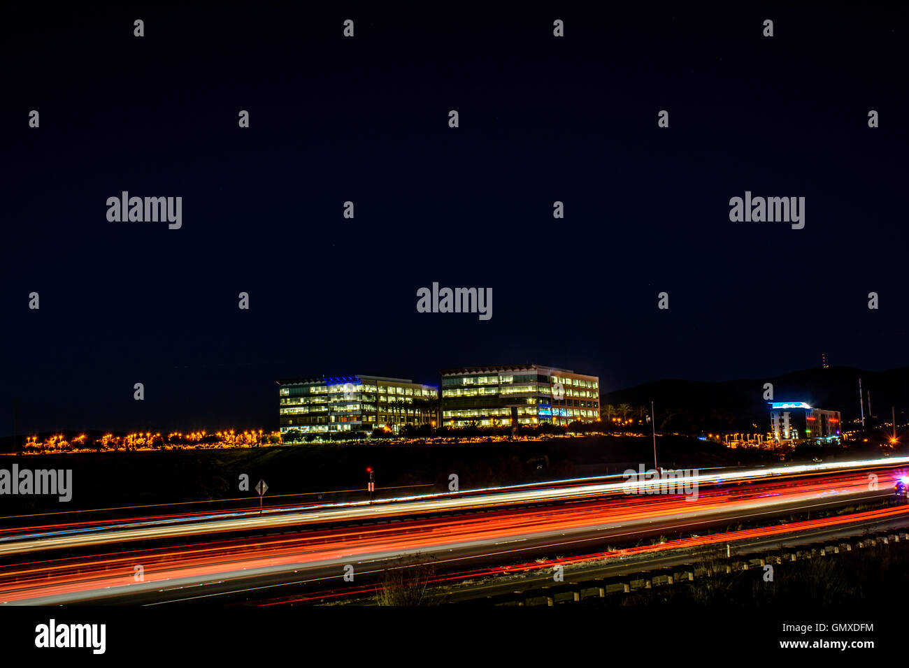 La trafficata autostrada e ufficio edificio presso la Silicon Valley. Una lunga esposizione per acquisire questo bellissimo paesaggio urbano di notte. Foto Stock