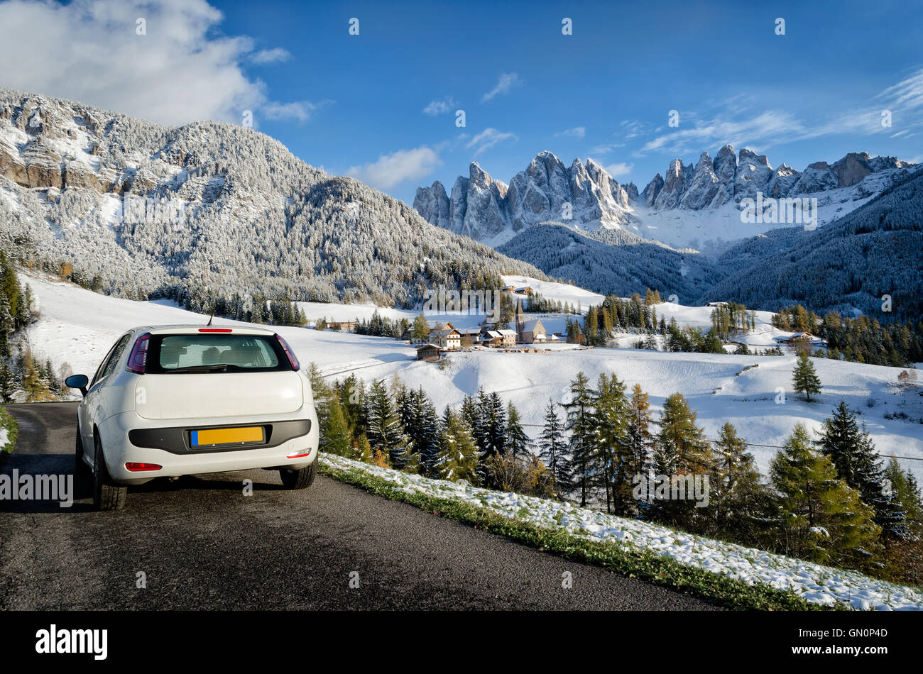 Bianco auto sulla strada durante un viaggio in un paesaggio delle Dolomiti in inverno con neve sugli alberi in Val di Funes, Italia Foto Stock