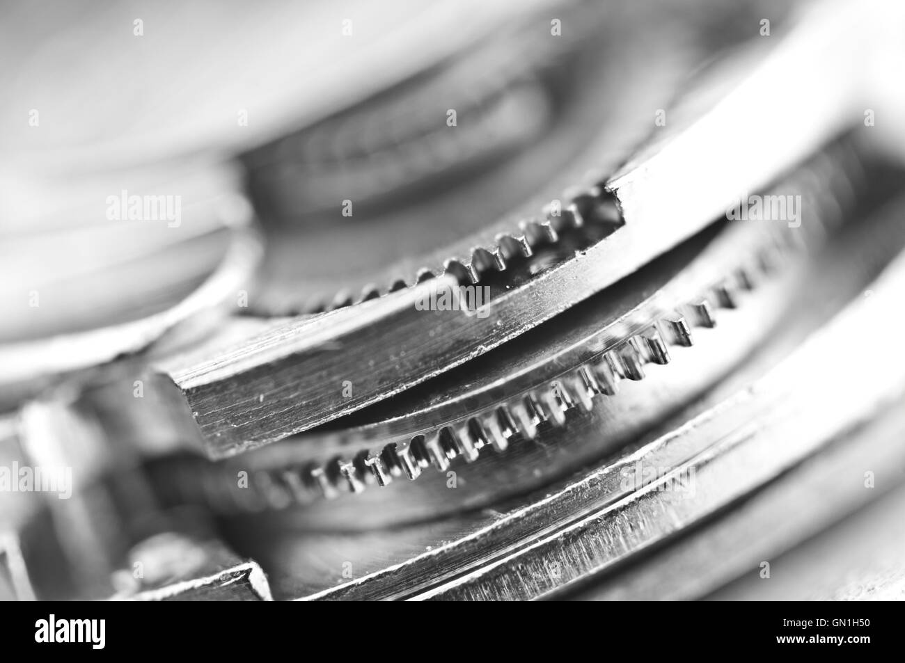Macro, nero lo sfondo bianco con ruote dentate metalliche un meccanismo a orologeria. Foto concettuale per il vostro business di successo di progettazione Foto Stock
