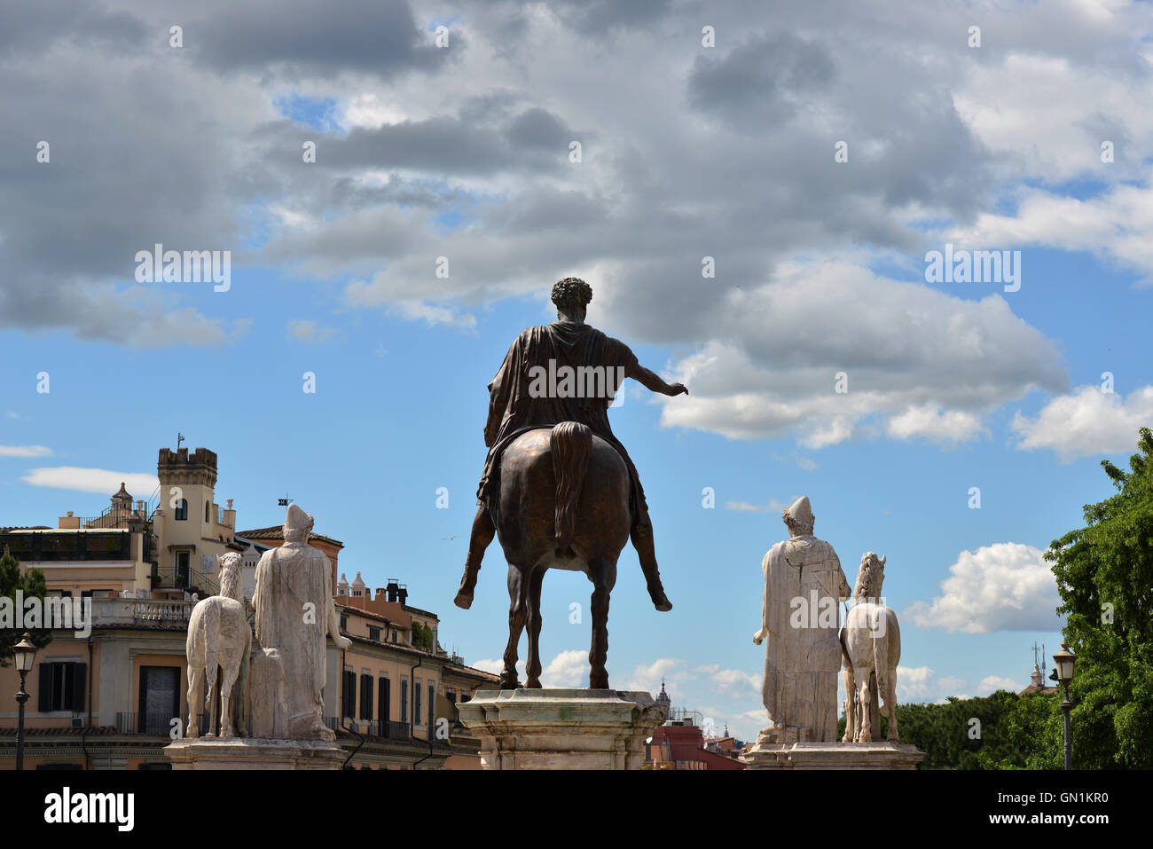 Antica statua romana dell'imperatore Marco Aurelio con due Dioskouri contro il cielo nuvoloso, sul Campidoglio a Roma Foto Stock