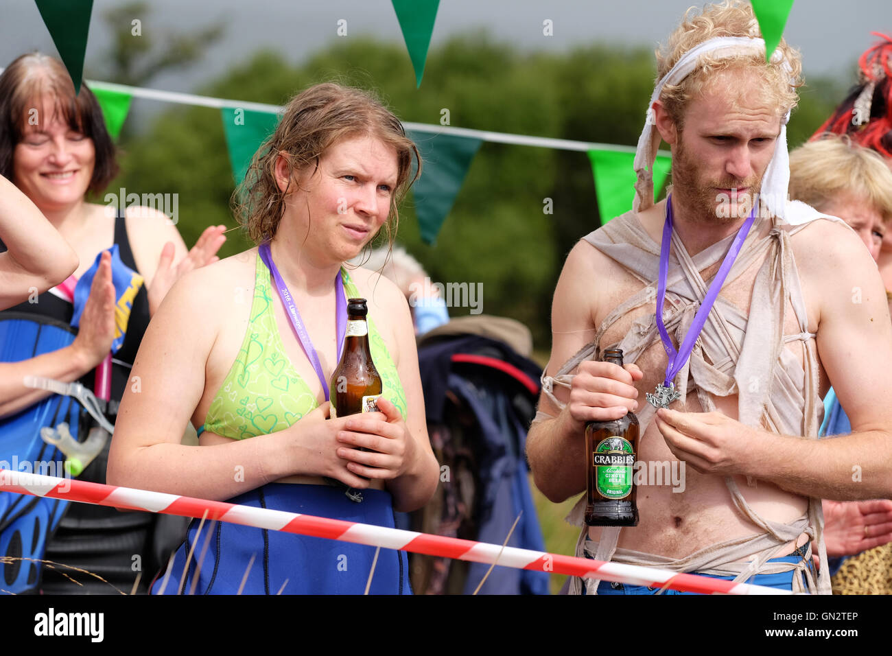 31 Mondo Bog Snorkelling campionati, Llanwrtyd Wells, Powys, Galles Agosto, 2016. - Concorrenti sorseggiare un drink dopo aver completato il loro fare snorkeling mentre guardando il concorrente successivo progresso a Waen Rhydd bog per il mondo della palude campionati di snorkeling nelle zone rurali del Galles Centrale. Foto Stock