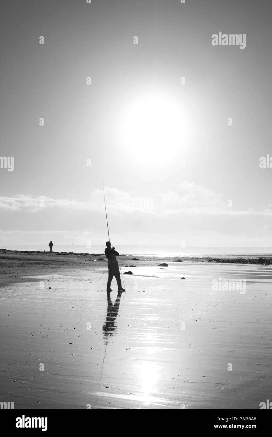 Pescatore solitario la pesca sulla spiaggia di Ballybunion contea di Kerry Irlanda in bianco e nero Foto Stock