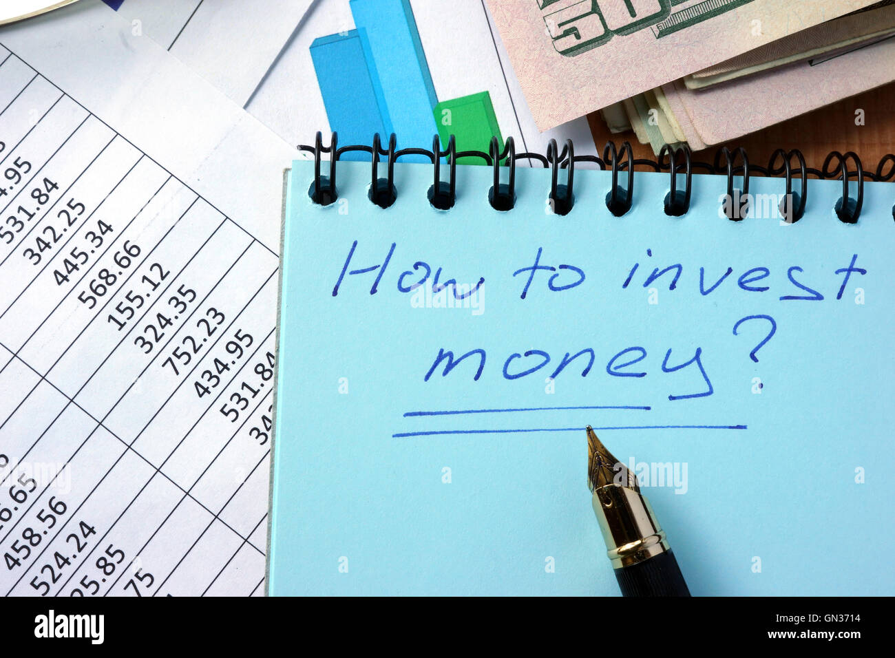 Blocco note con iscrizione come investire denaro su un tavolo. Foto Stock