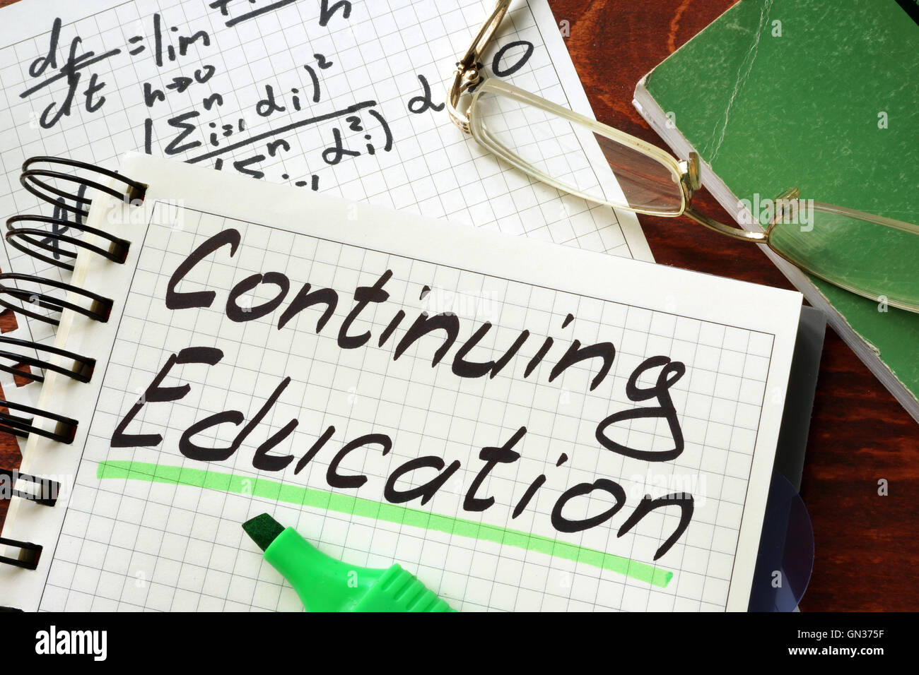 Segno di educazione permanente scritto in un blocco note su un tavolo. Foto Stock