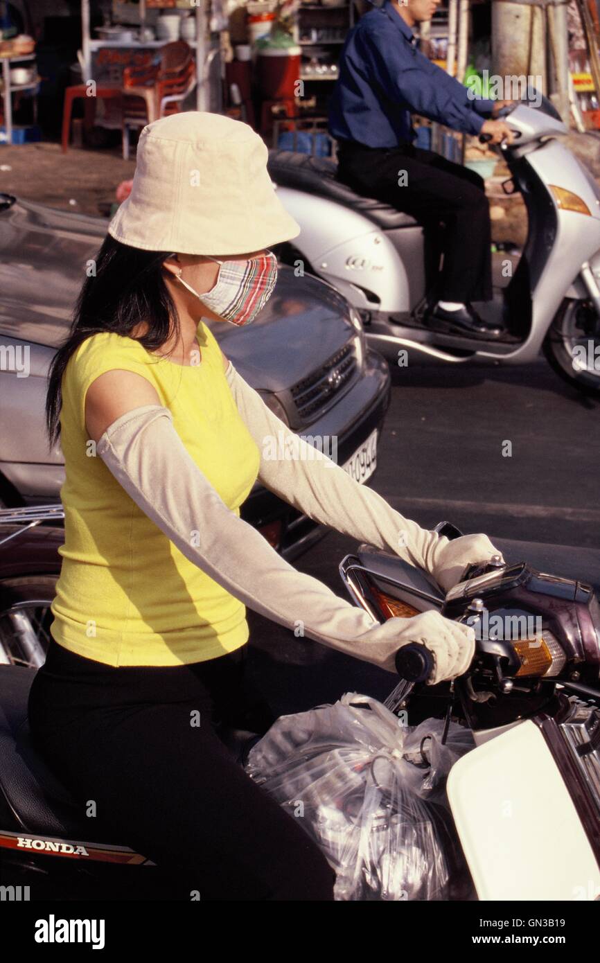 La città di Ho Chi Minh, Vietnam - 9 ottobre 2006. Per motociclisti alla moda indossando cofano, maschera facciale e guanti lunghi. Foto Stock