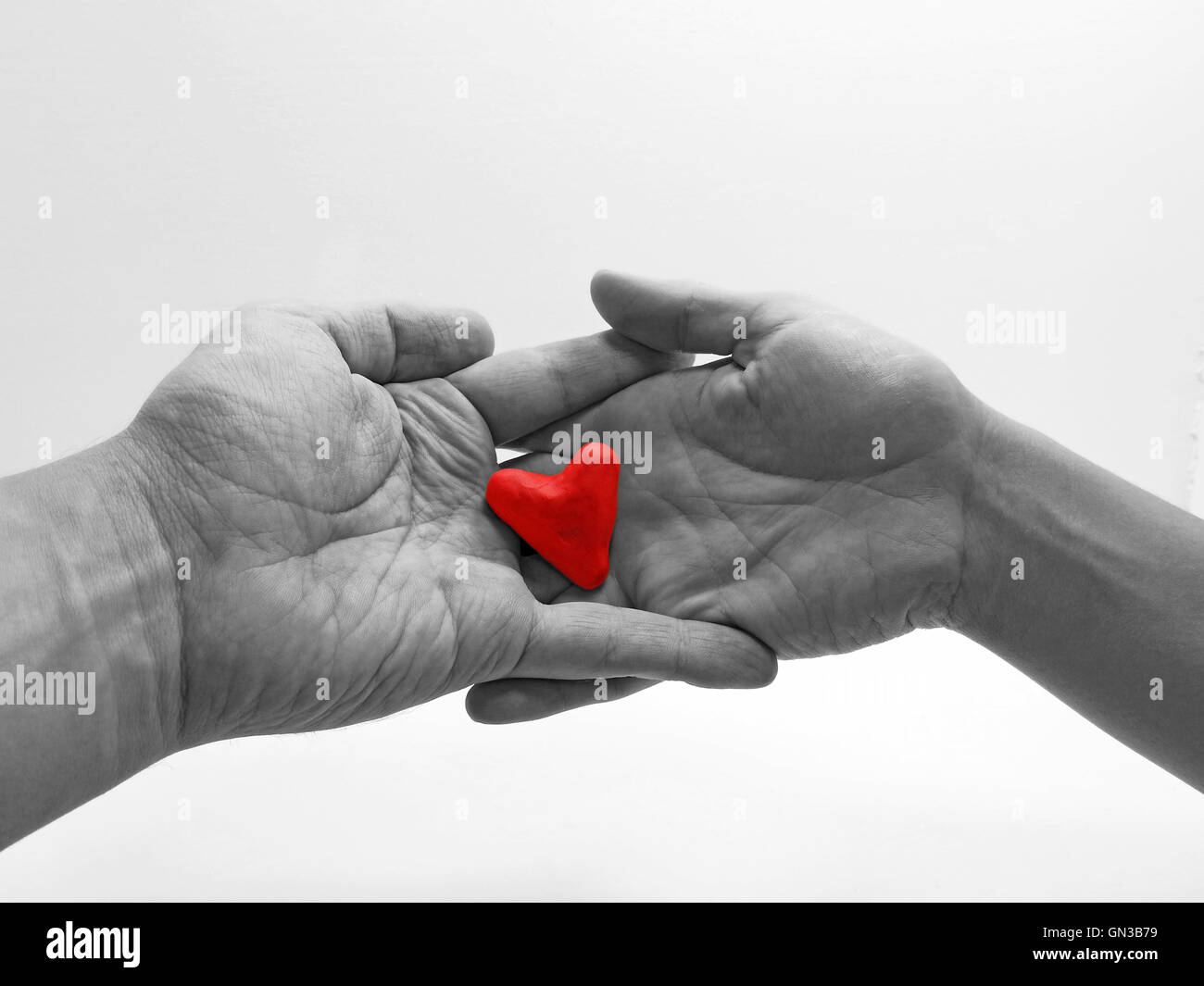 Uomo e donna mani con cuore rosso Foto stock - Alamy