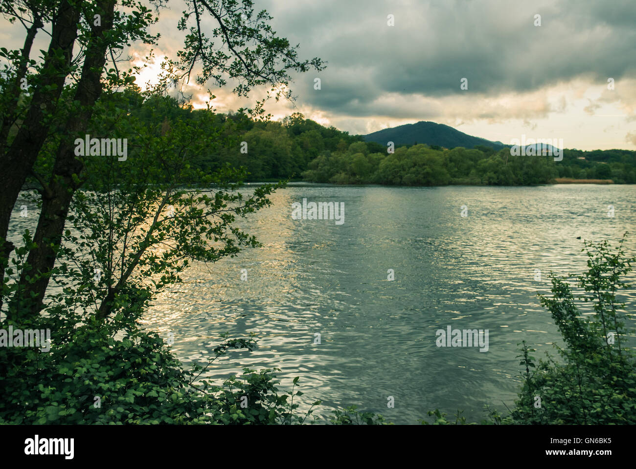 Fiume che scorre e la vegetazione con colline gli sfondi Foto Stock