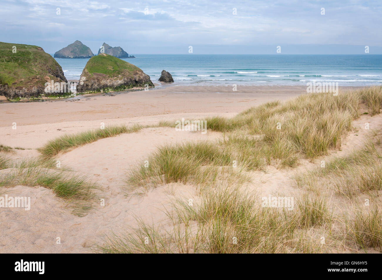 La spiaggia di Holywell Bay sulla costa della Cornovaglia, Inghilterra. Vista guardando il mare e le rocce noto come rocce di gabbiano. Foto Stock