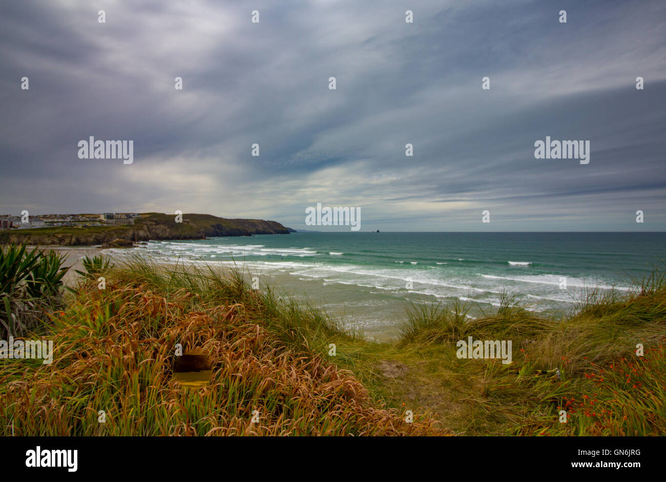 Polzeath Beach, Cornwall raffigurato su un nuvoloso, peperoncino pomeriggio d'estate. Immagine presa dal sentiero costiero sopra la spiaggia. Foto Stock