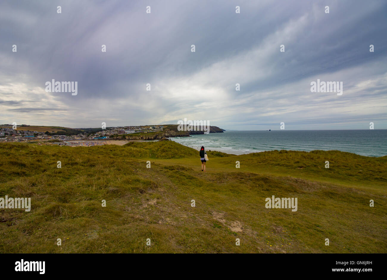 Polzeath Beach, Cornwall raffigurato su un nuvoloso, peperoncino pomeriggio d'estate. Immagine presa dal sentiero costiero sopra la spiaggia. Foto Stock