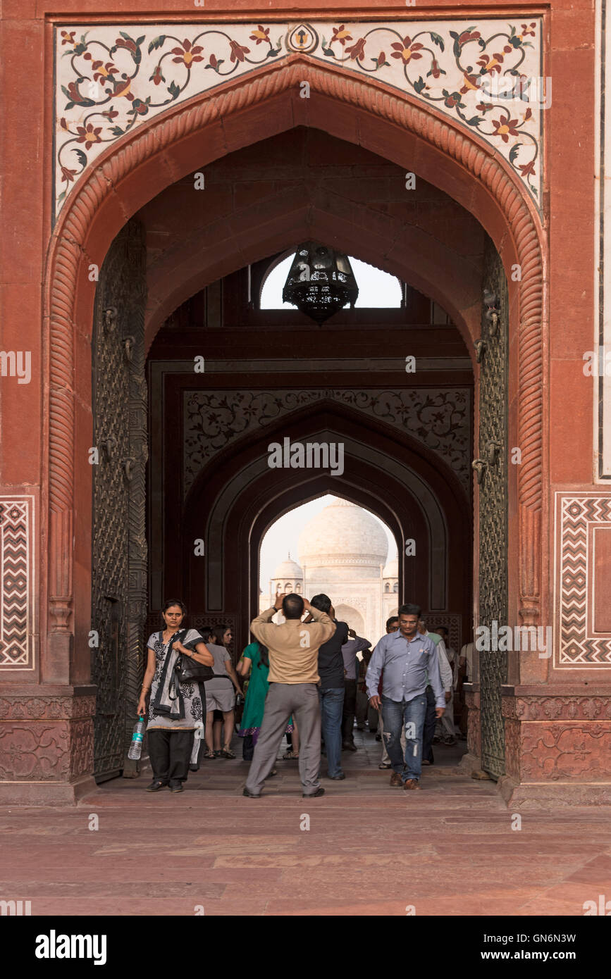 I visitatori a piedi sotto il grande arco della grande porta (Darwaza-i) rauza al Taj Mahal Agra, Uttar Pradesh, India Foto Stock